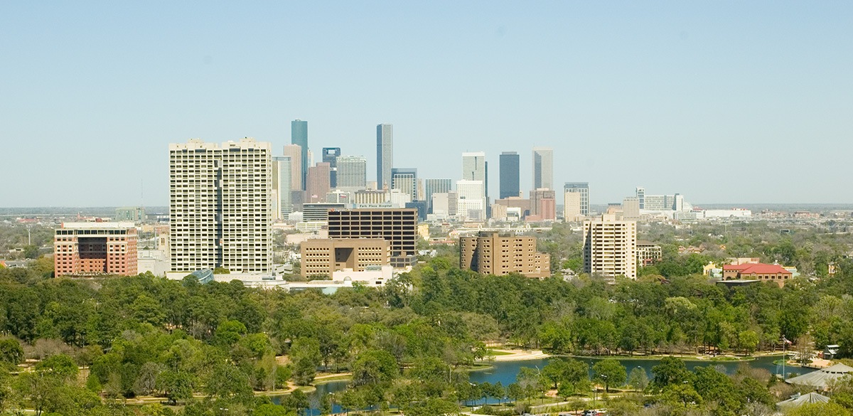The skyline of the Museum District in the foreground, and the skyline of Downtown Houston in the background. Midtown is between Downtown and the Museum District.